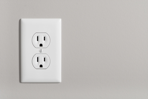 A,white,home,electrical,outlet,on,a,light,grey,wall.